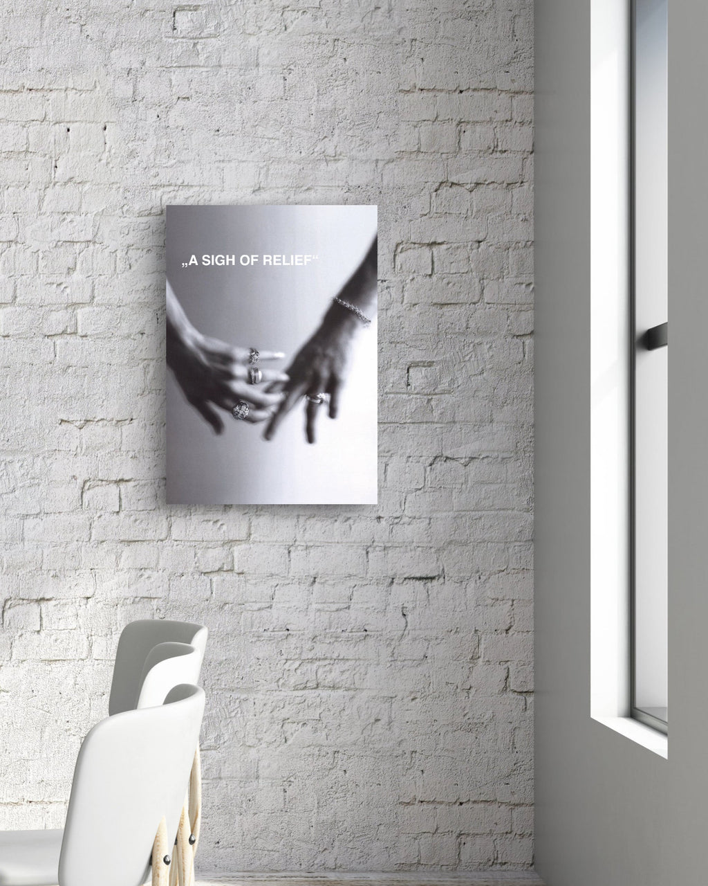 Modern interior with a table and chairs against a white brick wall with a framed picture.