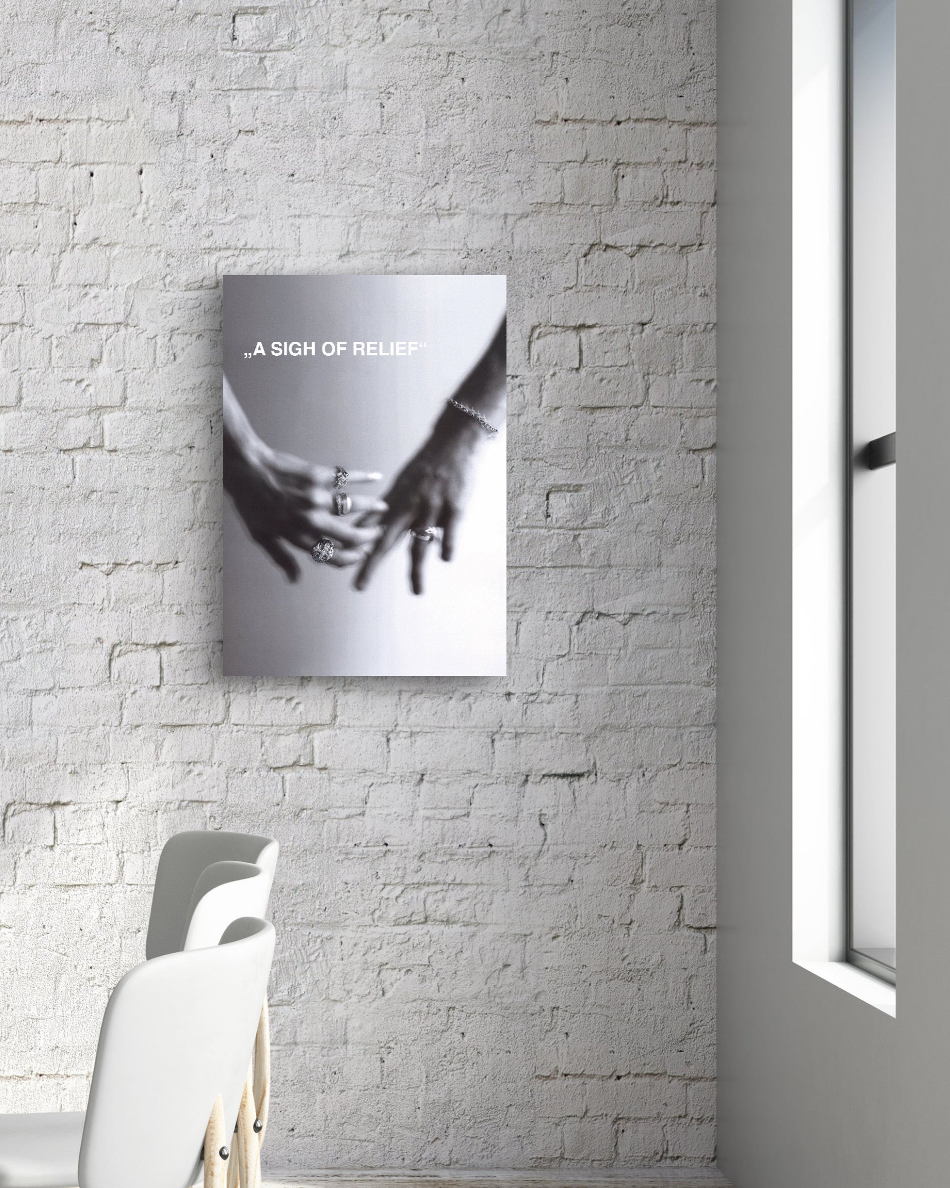 Modern interior with a table and chairs against a white brick wall with a framed picture.