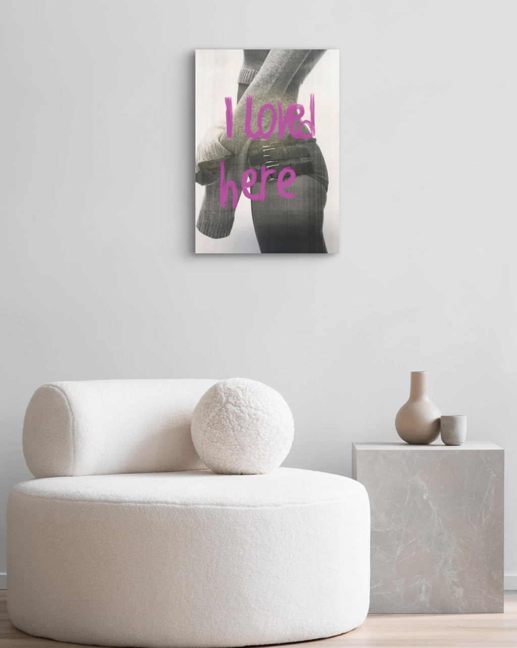 White armchair in a room with a wall art piece displaying text.