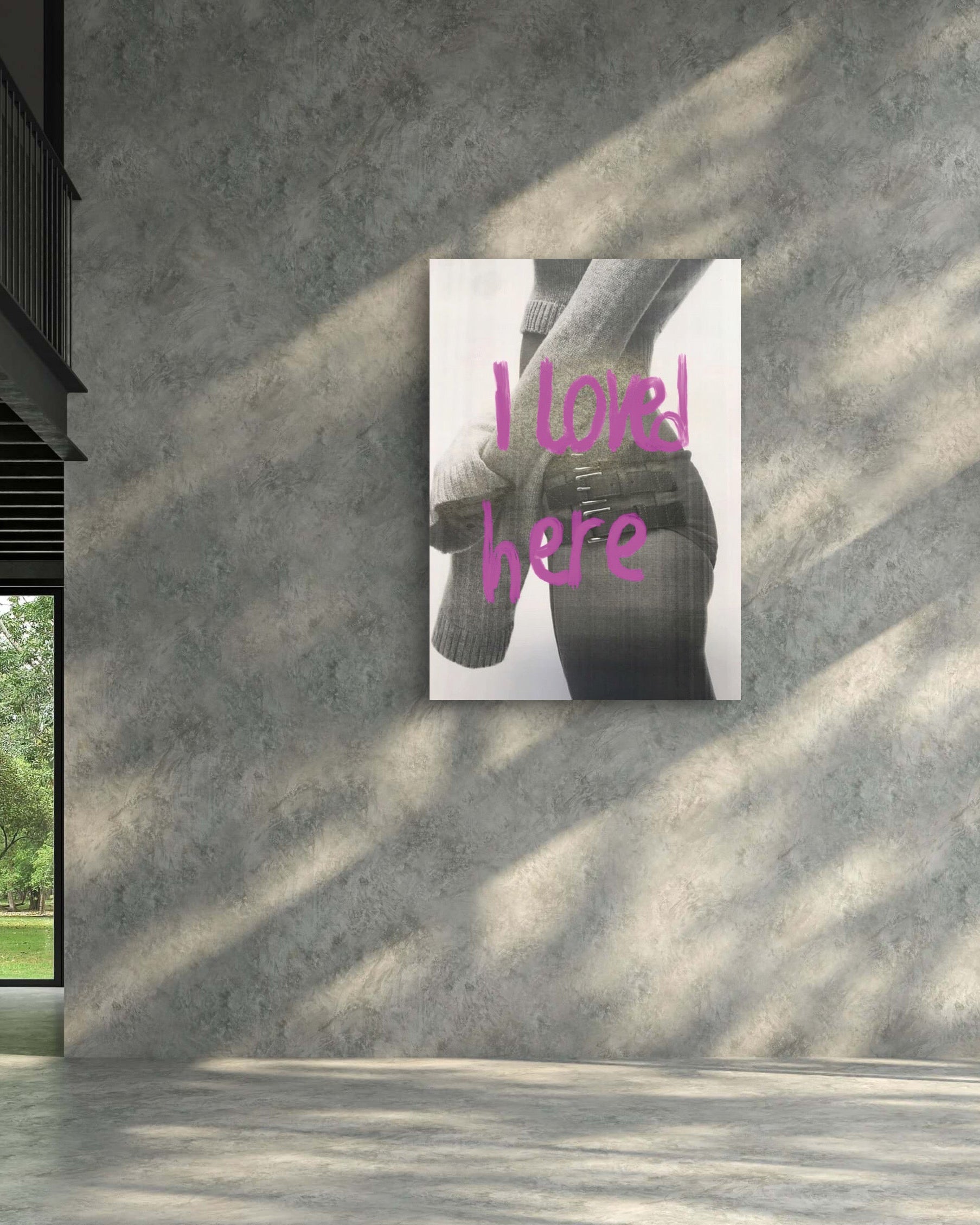 Modern interior with a concrete wall and a framed picture of a hand holding a heart.